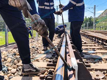 Railway workers installing and aligning a check rail